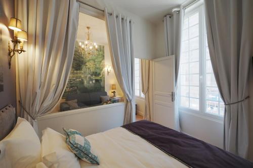 - une chambre avec un lit et une grande fenêtre dans l'établissement Louvre Opera Design ChicSuites, à Paris