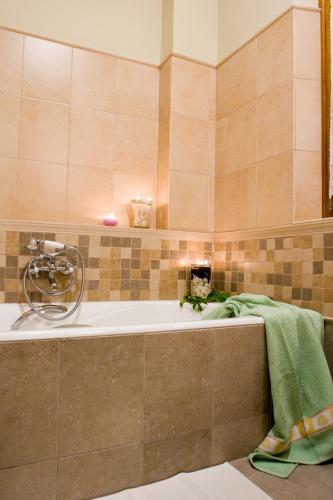 ein Badezimmer mit einer Badewanne, auf der ein grünes Handtuch liegt in der Unterkunft Stolios Skopelos - Panoramic Seaview Gems in Skopelos