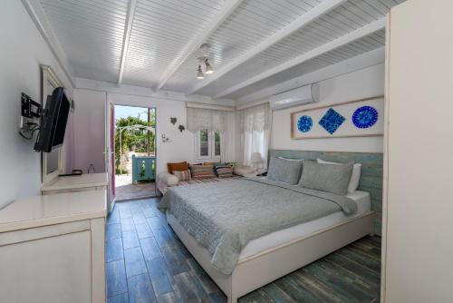 a bedroom with a large bed and a television at Kefi Beach & Suites in Ortakent