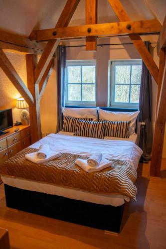 a large bed in a room with two windows at Sophienhof in Bad Berka