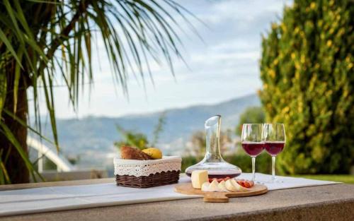 a table with two glasses of wine and food on it at Casa do Paraíso in Gemieira