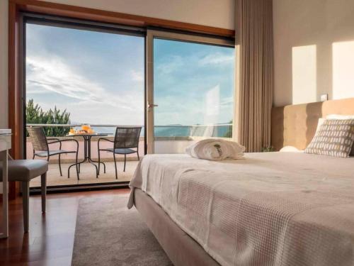 a bedroom with a bed and a balcony with a table at Casa do Paraíso in Gemieira