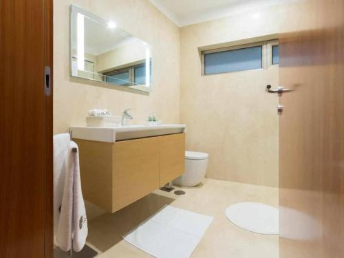 a bathroom with a sink and a toilet and a mirror at Casa do Paraíso in Gemieira