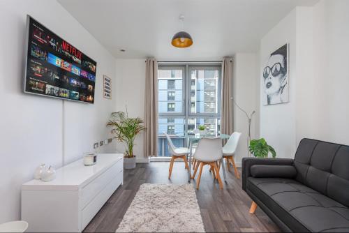 a living room with a couch and a table at Stratford Central Apartment in London