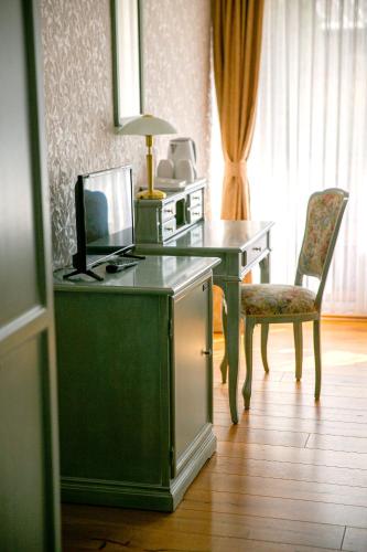 a room with a desk with a computer and a television at Gästehaus Maasberg in Bad Sobernheim
