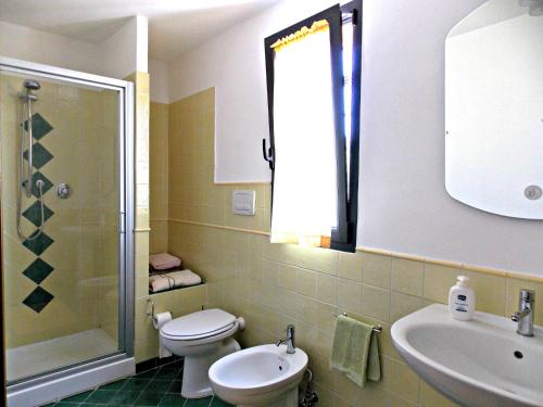ein Bad mit einem WC, einem Waschbecken und einer Dusche in der Unterkunft Casa Paola in Molino del Piano