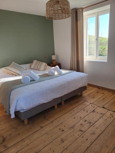a bedroom with a bed with white sheets and a window at Domaine des Granges in La Bâtie-Montgascon