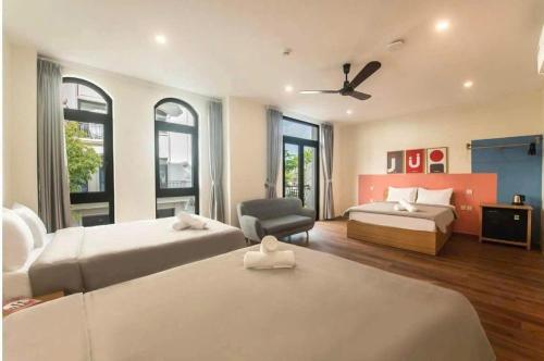 a large bedroom with two beds and a chair at Thanh hoa HOMESTAY in Hòa Bình