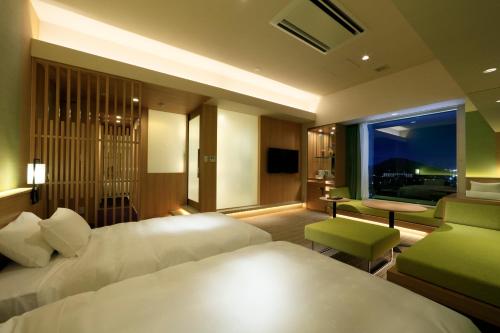 a hotel room with two beds and a window at Candeo Hotels Nara Kashihara in Kashihara