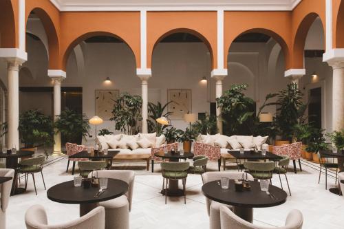 a lobby with tables and chairs in a building at Palacio Pinello in Seville