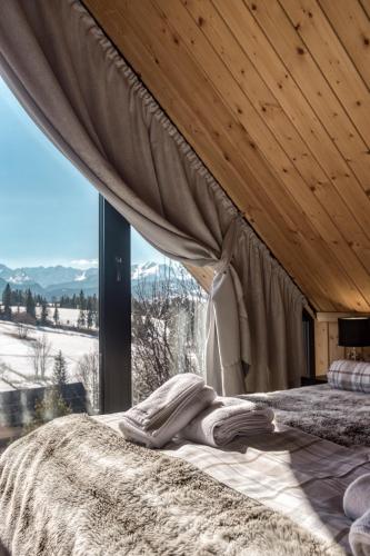 a bedroom with a bed with a large window at RzepiskaView in Rzepiska