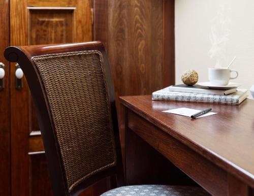 a wooden table with a chair and a cup on a book at Hotel Rua Villar in Santiago de Compostela