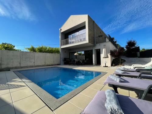 a house with a swimming pool in front of a house at Casa das Branquinhas - Férias no Minho com piscina! in Ponte de Lima