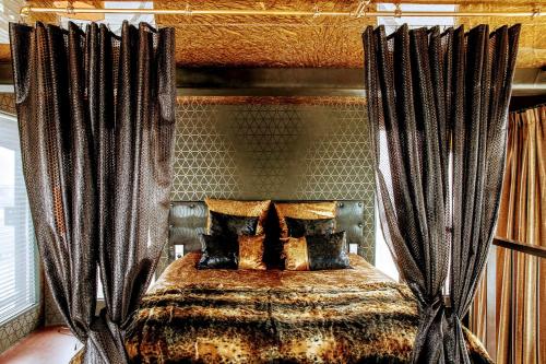 a bedroom with a bed with black curtains at Faralda Crane Hotel in Amsterdam