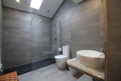 a bathroom with a sink and a toilet and a shower at Casa das Branquinhas - Férias no Minho com piscina! in Ponte de Lima