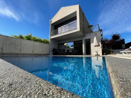 a house with a swimming pool in front of a house at Casa das Branquinhas - Férias no Minho com piscina! in Ponte de Lima