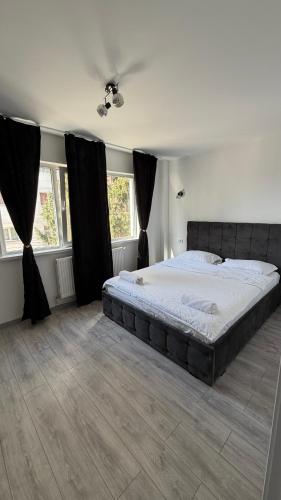 a bedroom with a large bed with black curtains at Luxury Lion Crib in Bacău