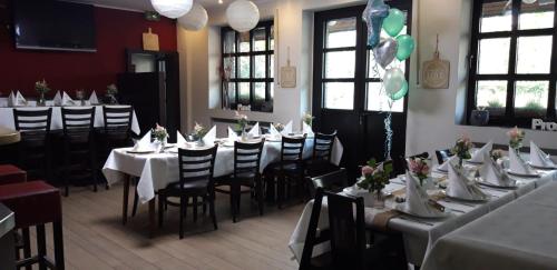 a dining room with tables and chairs with flowers on them at Restaurant Zur Linde in Bergheim