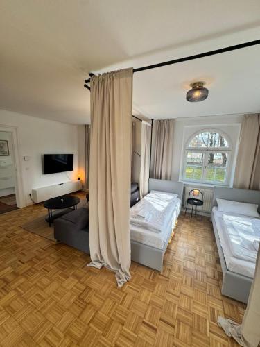 a living room with two beds and a tv at Bavaria Home - Terrasse, Küche, Parken in Geisenfeld