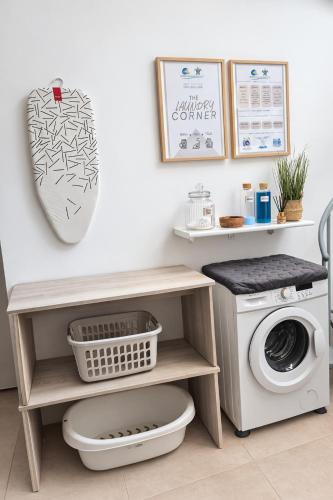 a laundry room with a washing machine and a sink at Green Bay Suites in Protaras