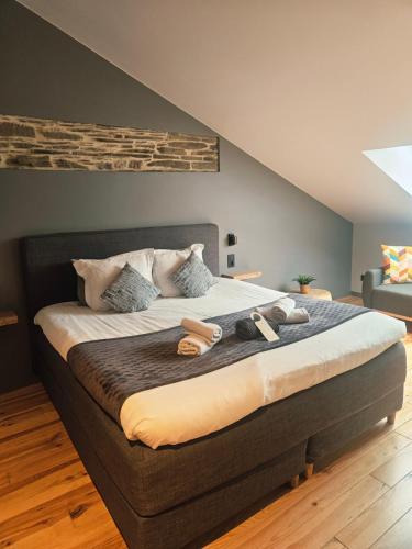 a large bed with two pairs of shoes on it at Le Cerf d'Or in Herbeumont