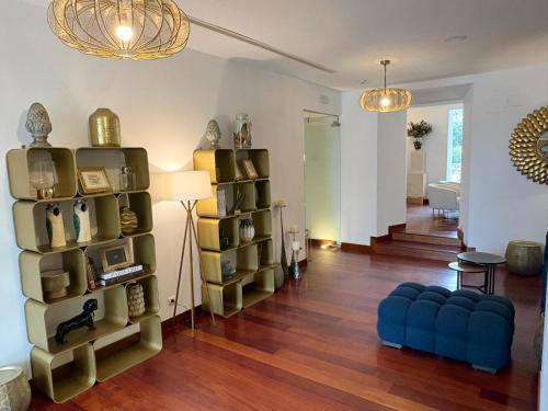 a living room with a book shelf and a blue couch at Hotel Boutique Palacio del Moral in Ronda
