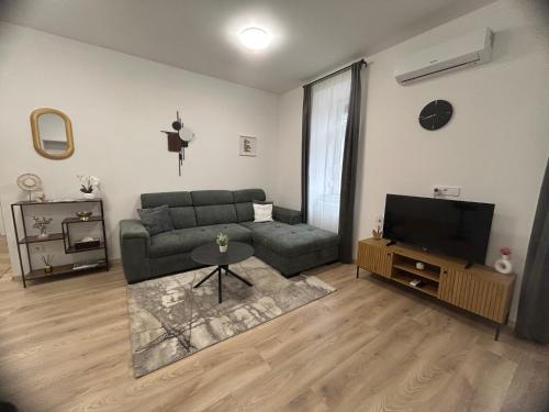 a living room with a couch and a television at R03 Central Residence in Sopron