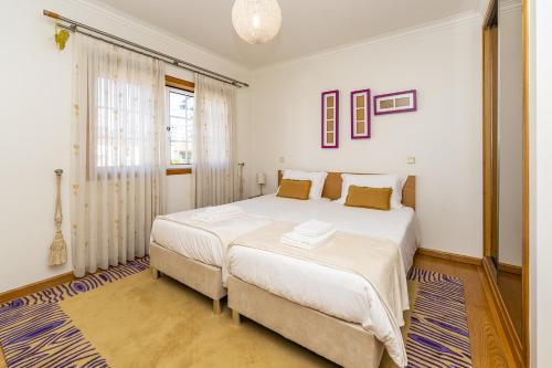 a bedroom with two beds and a window at Family Beach House in Amorosa, Northern Portugal in Amorosa
