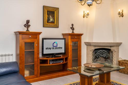 a living room with a tv and a fireplace at Family Beach House in Amorosa, Northern Portugal in Amorosa