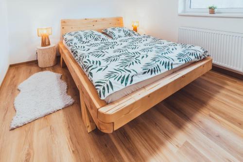 a bed in a bedroom with a wooden floor at U Ztraceného potoka in Vápenná