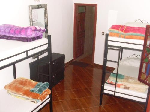 a room with three bunk beds and a mirror at The Medina Hostel in Tangier