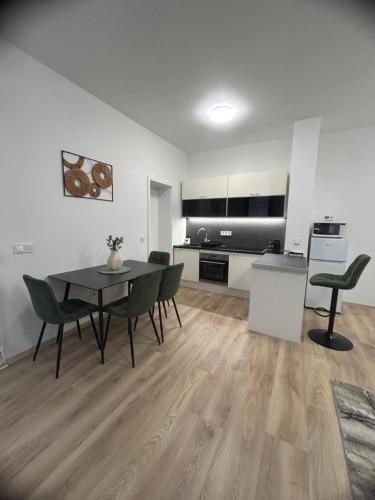 a living room with a table and chairs and a kitchen at R03 Central Residence in Sopron