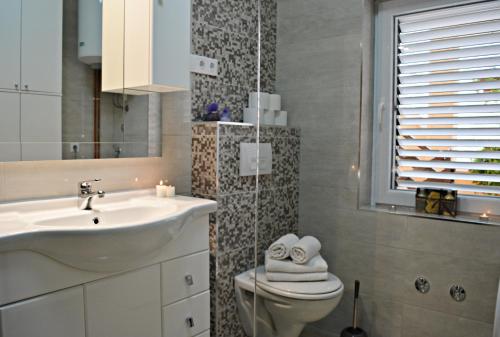 y baño con lavabo, aseo y espejo. en Apartments Ćurić, en Trogir