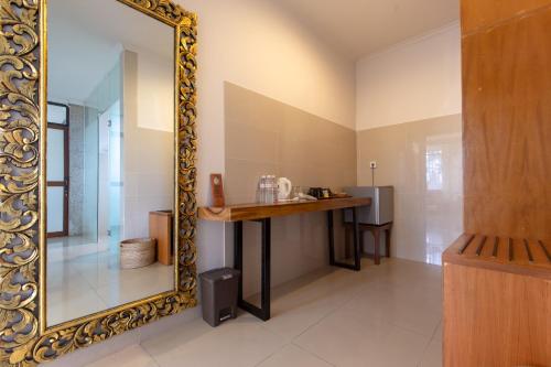 a mirror in a room with a vanity and a table at Om Ham Retreat and Resort in Ubud