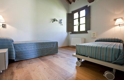 a room with two beds and a window at Spa Resort Fonte Alla Lepre in Riparbella