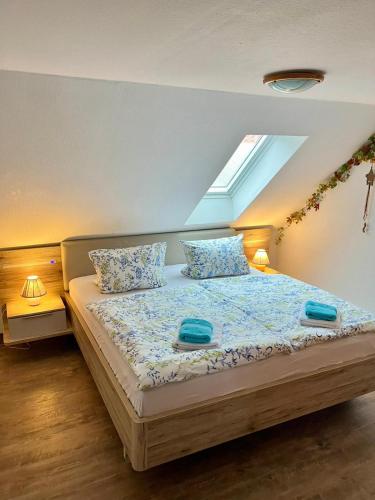 a bedroom with a bed with two blue towels on it at Dat Kapitänshuus in Carolinensiel