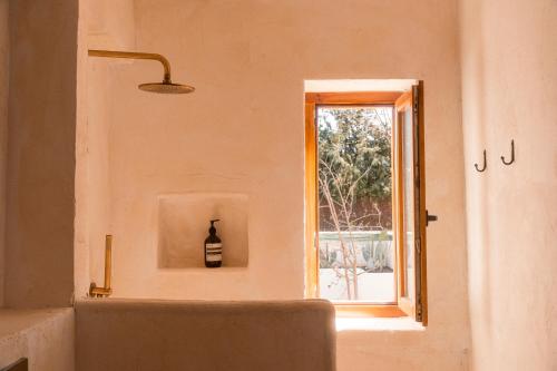 a bottle of wine sitting on a wall next to a window at Casa Valentina Ronda in Ronda