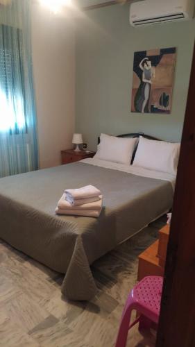 a bedroom with a large bed with towels on it at Sea Side View in Dhíkella