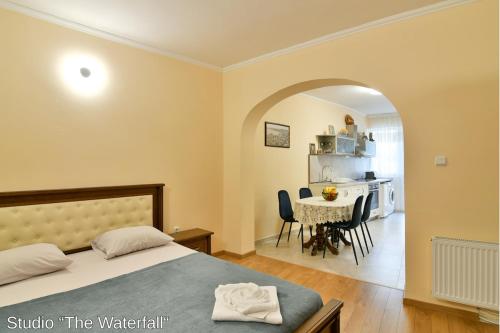 a bedroom with a bed and a table with chairs at Studio The Waterfall - Free Parking in Balchik