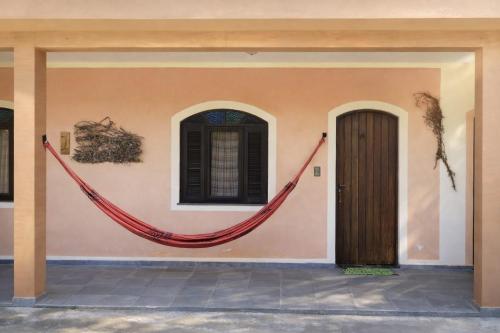 a building with a red hammock on the side of it at Pousada Atelier Aly da Costa in Iguape