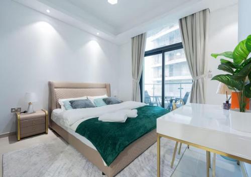 a bedroom with a bed with a green blanket and a desk at Bohemian Rhapsody in Kuwait