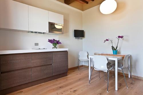 a kitchen with a table and chairs and a counter at Spa Resort Fonte Alla Lepre in Riparbella