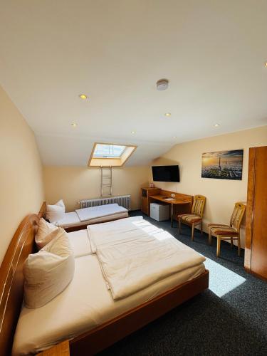 a bedroom with a bed and a desk and a computer at Hotel Europa Pforzheim in Pforzheim