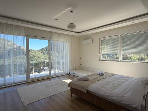 a bedroom with a large bed and a large window at Villa Leom - Mountain Villa with Pool in Antalya in Gedeller