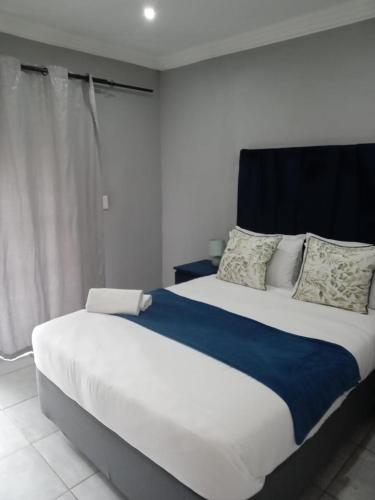 a bedroom with a large bed with a blue blanket at Efkay Guest in Thohoyandou