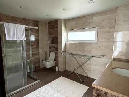 a bathroom with a shower and a toilet and a sink at Villa Leom - Mountain Villa with Pool in Antalya in Gedeller