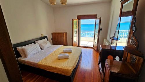 a bedroom with a bed with a view of the ocean at Potokaki Coastal Haven in Potokáki