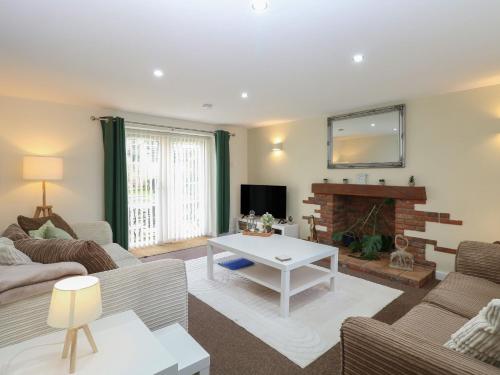 a living room with a couch and a fireplace at Sleepeezy in Kettlestone