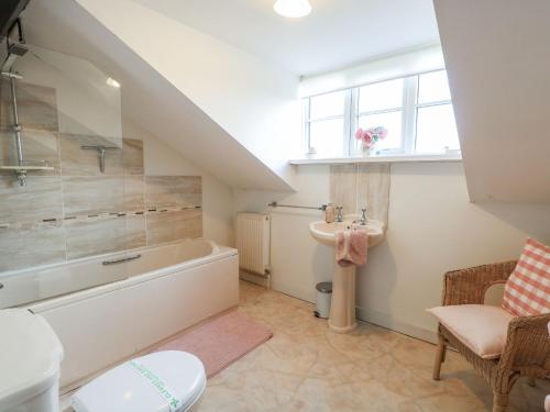 a bathroom with a bath tub and a sink at Sleepeezy in Kettlestone