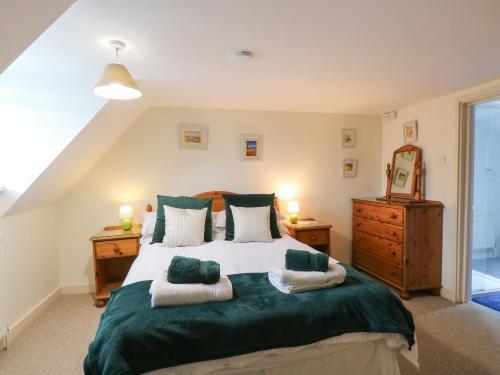 a bedroom with a large bed with green sheets and pillows at Sleepeezy in Kettlestone